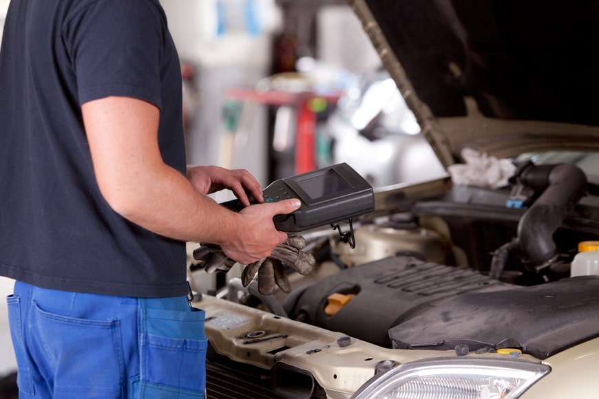 Skilled mechanic performing engine diagnostics using specialized tool for accurate troubleshooting and repair.