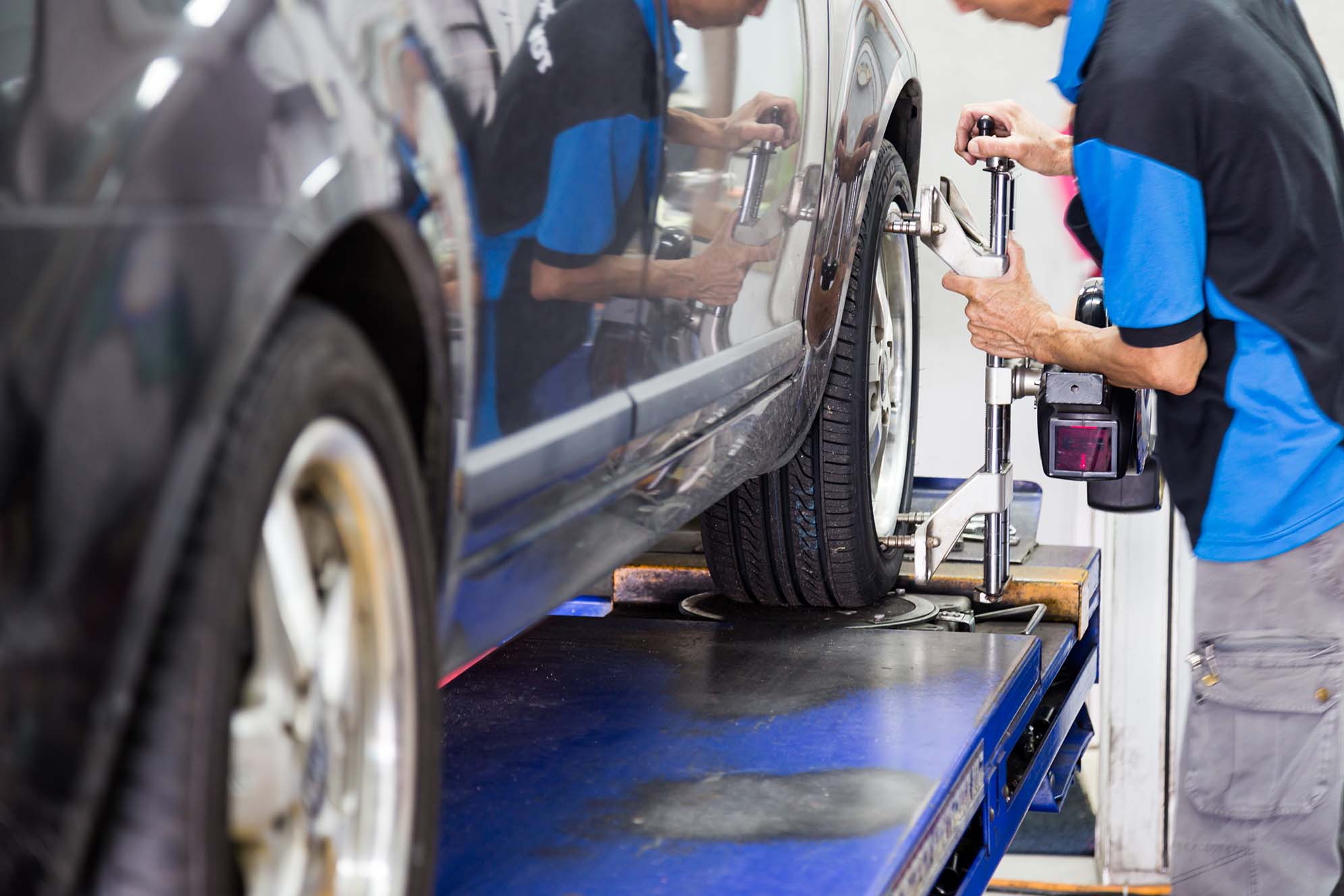 Skilled mechanic performing precise wheel alignment