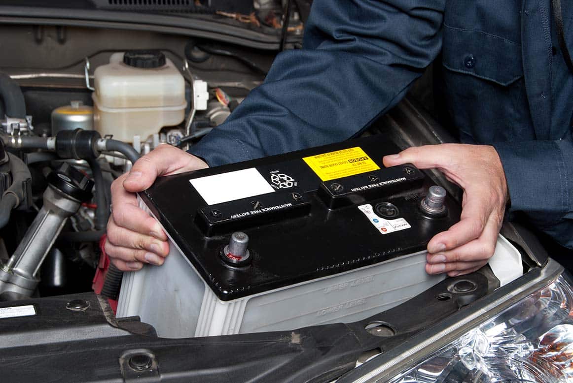 A Mechanic starting to work on a car battery after charging.