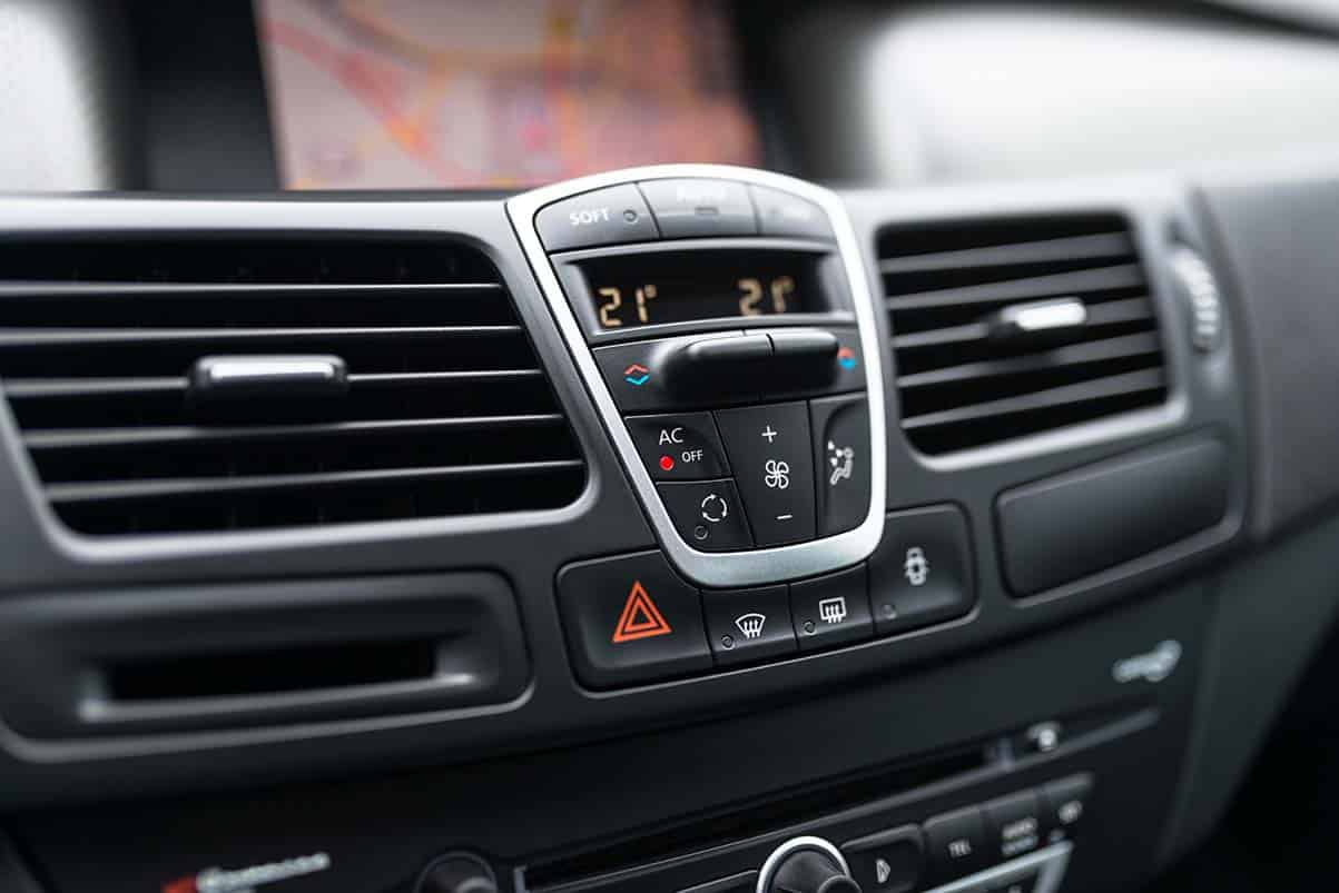 Close-up of car control panel with air conditioning buttons and vents for climate control