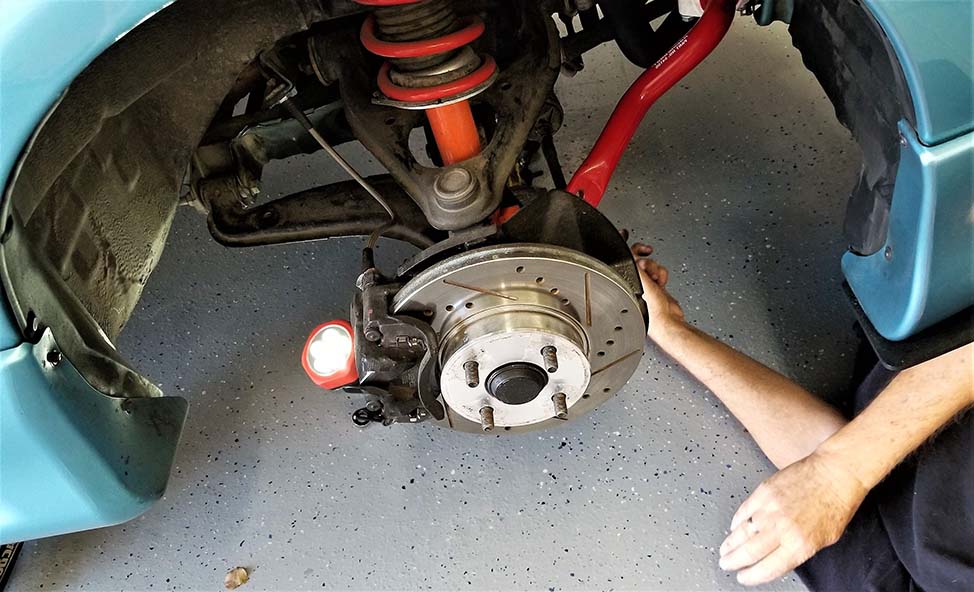 Mechanic inspecting and adjusting steering and suspension components for optimal performance and ride comfort