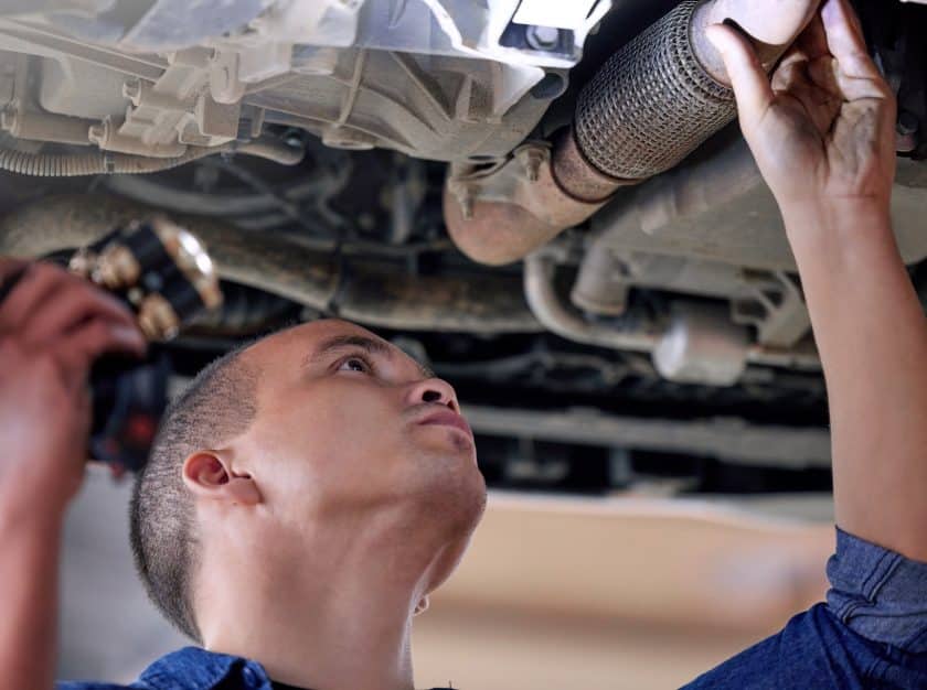 Car mechanic conducting a service inspection, identifying and addressing potential car leaking issues.