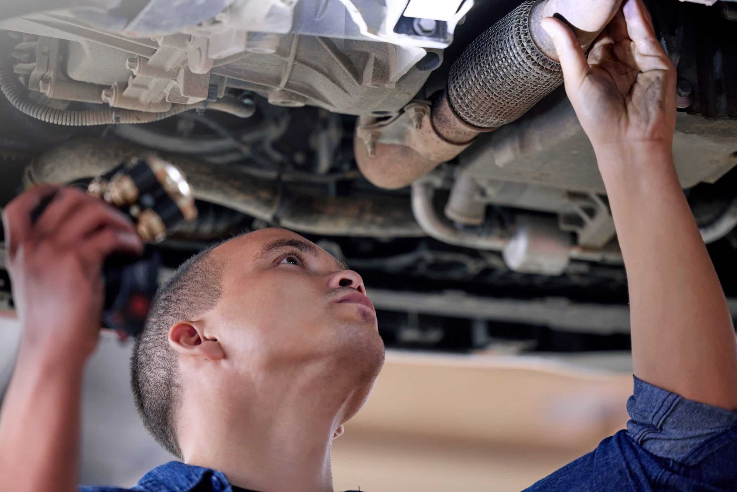 Car mechanic conducting a service inspection, identifying and addressing potential car leaking issues.